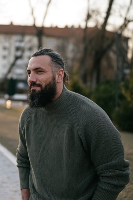 Benjamin Faci debout dans une allée de parc au crépuscule, les mains derrière le dos